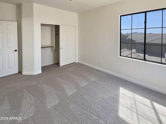 unfurnished bedroom with a closet and carpet flooring