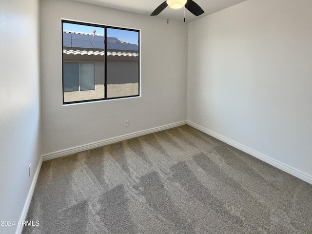 carpeted spare room featuring ceiling fan