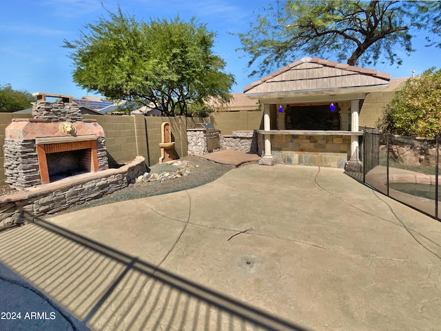 view of patio / terrace featuring a gazebo and an outdoor stone fireplace