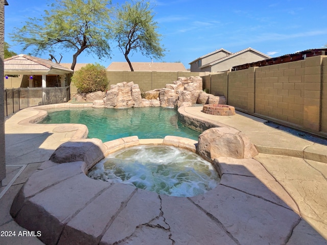 view of pool with a gazebo and an in ground hot tub