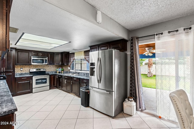 kitchen with backsplash, dark brown cabinets, ceiling fan, stainless steel appliances, and light tile patterned floors