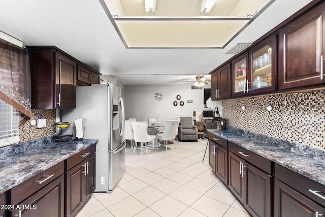 kitchen with dark brown cabinets, backsplash, stainless steel fridge with ice dispenser, light tile patterned floors, and ceiling fan