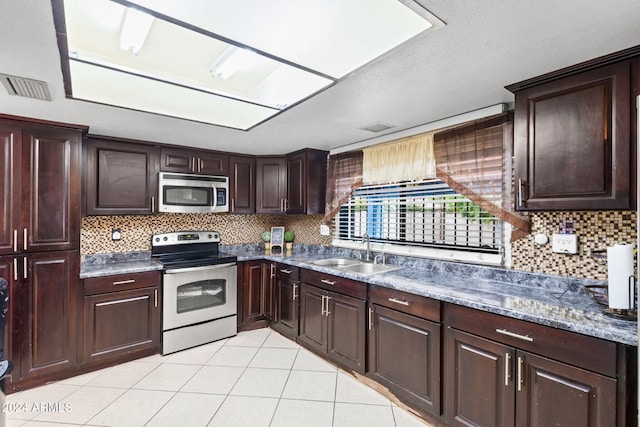 kitchen with light tile patterned floors, tasteful backsplash, appliances with stainless steel finishes, and sink