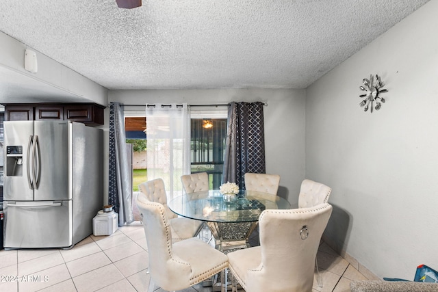 dining space featuring a textured ceiling and light tile patterned flooring