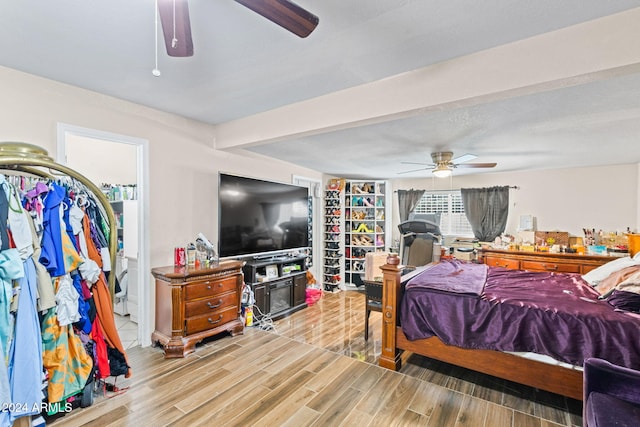 bedroom with ensuite bath, a textured ceiling, and hardwood / wood-style floors