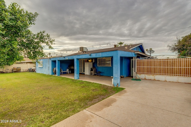 rear view of property featuring a yard and a patio area