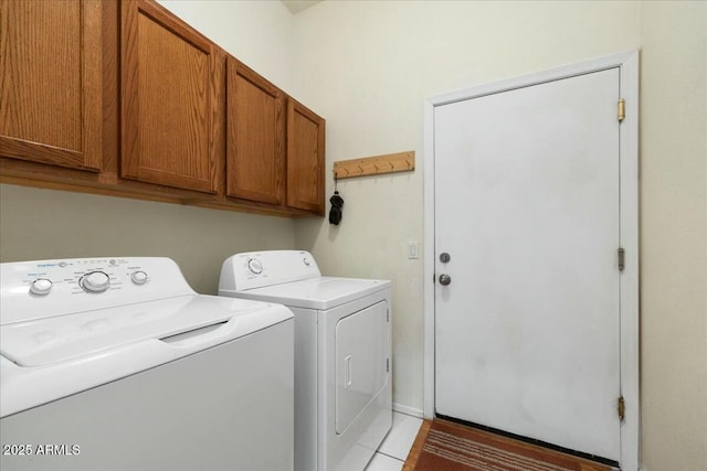 clothes washing area featuring cabinets and independent washer and dryer