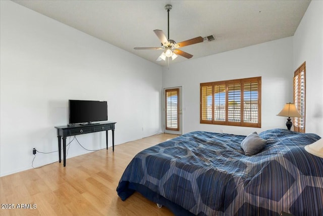 bedroom with ceiling fan, lofted ceiling, and hardwood / wood-style floors