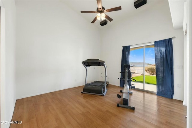 exercise area featuring hardwood / wood-style floors, high vaulted ceiling, and ceiling fan