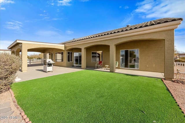 rear view of property featuring a patio and a lawn