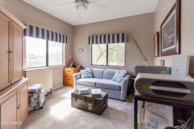 interior space featuring light carpet, ceiling fan, and baseboards