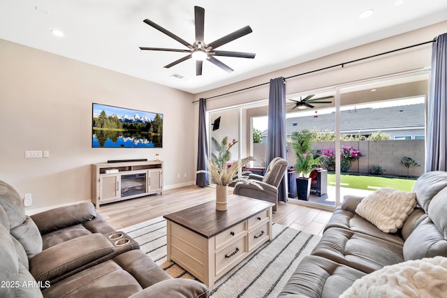 living room featuring ceiling fan and light hardwood / wood-style flooring