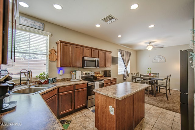 kitchen with appliances with stainless steel finishes, a sink, a ceiling fan, a center island, and recessed lighting