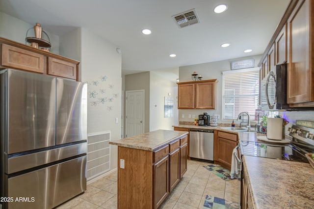 kitchen featuring appliances with stainless steel finishes, a sink, a kitchen island, recessed lighting, and light tile patterned floors