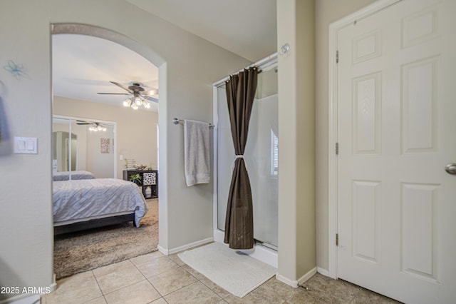 full bathroom with a shower stall, a ceiling fan, connected bathroom, tile patterned floors, and baseboards