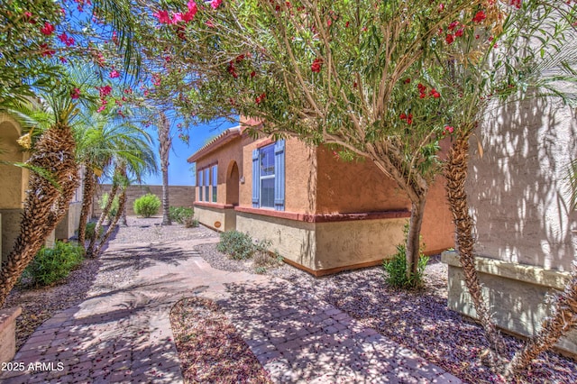 view of side of property with a fenced backyard, stucco siding, and a patio area