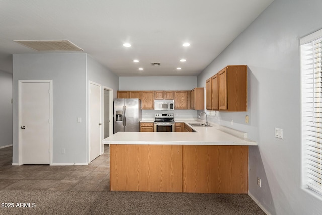 kitchen featuring stainless steel appliances, kitchen peninsula, and sink