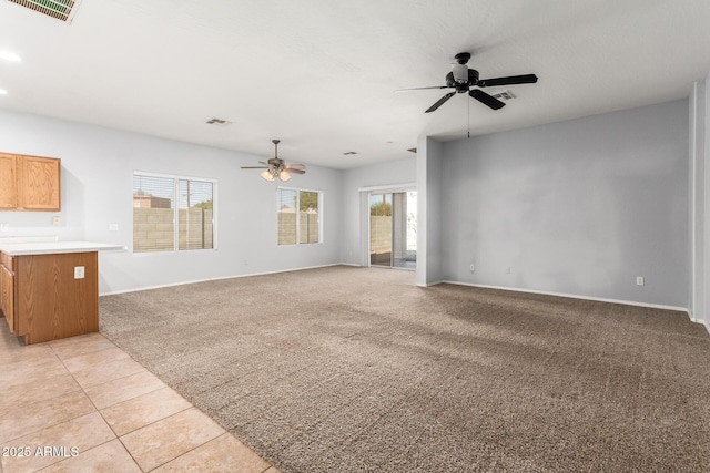 unfurnished living room featuring light carpet and ceiling fan