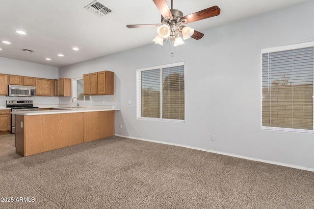 kitchen featuring sink, ceiling fan, kitchen peninsula, stainless steel appliances, and light carpet