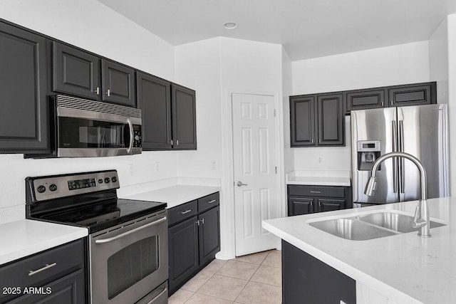 18525 N Larkspur Dr, Maricopa, AZ 85138 - kitchen with appliances with stainless steel finishes, a sink, light stone counters, dark cabinets, and light tile patterned flooring
