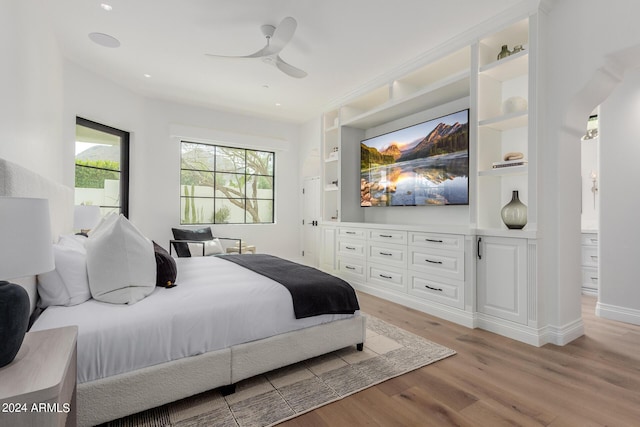 bedroom featuring ceiling fan, light hardwood / wood-style floors, and connected bathroom