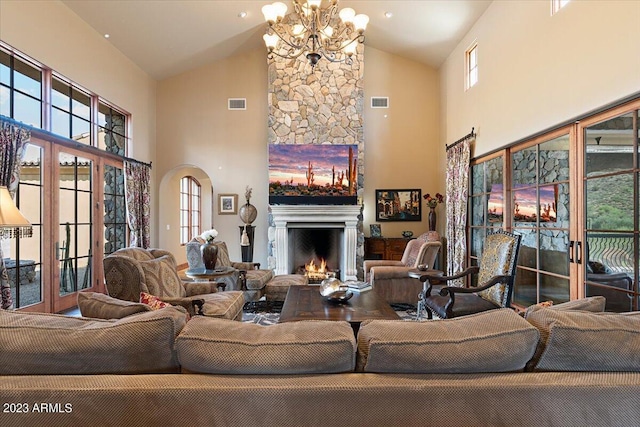 living room with a stone fireplace, french doors, and high vaulted ceiling