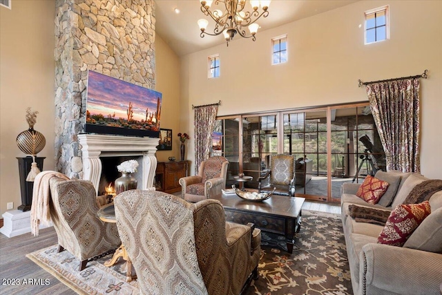 living room featuring high vaulted ceiling, a chandelier, a fireplace, and hardwood / wood-style floors