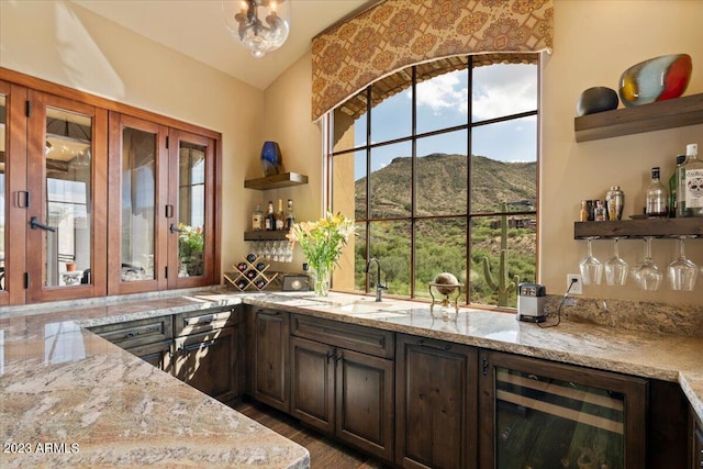 bar featuring a mountain view, wine cooler, and light stone counters