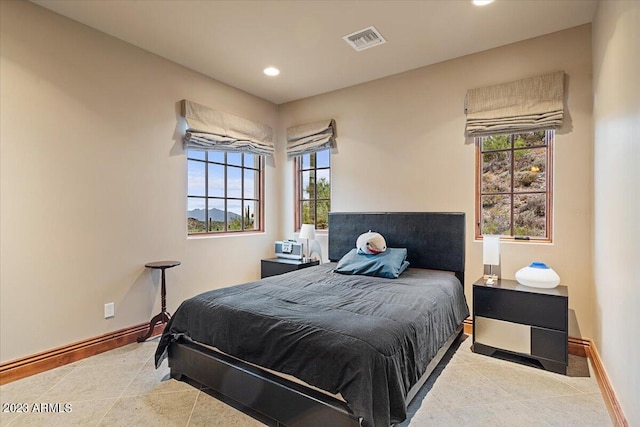 tiled bedroom with multiple windows