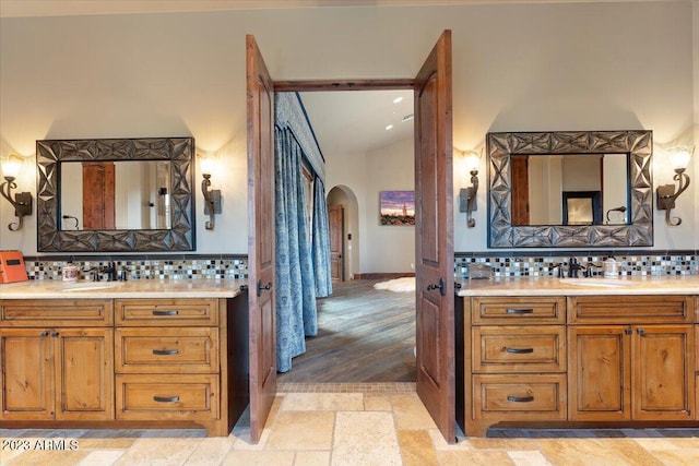 bathroom with vanity, decorative backsplash, and wood-type flooring