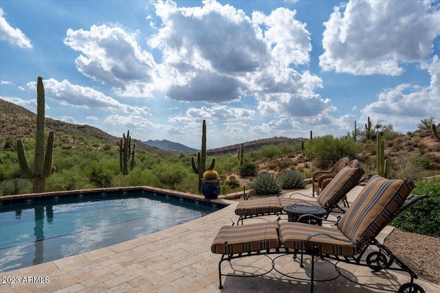 view of swimming pool with a mountain view and a patio area