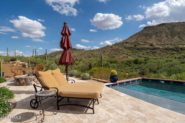 view of pool with a mountain view and a patio area