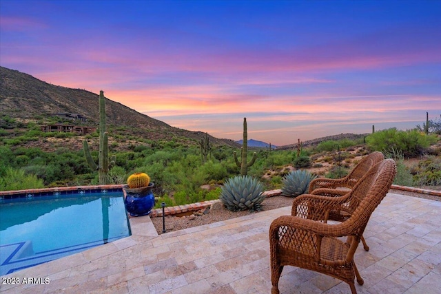 patio terrace at dusk featuring a mountain view