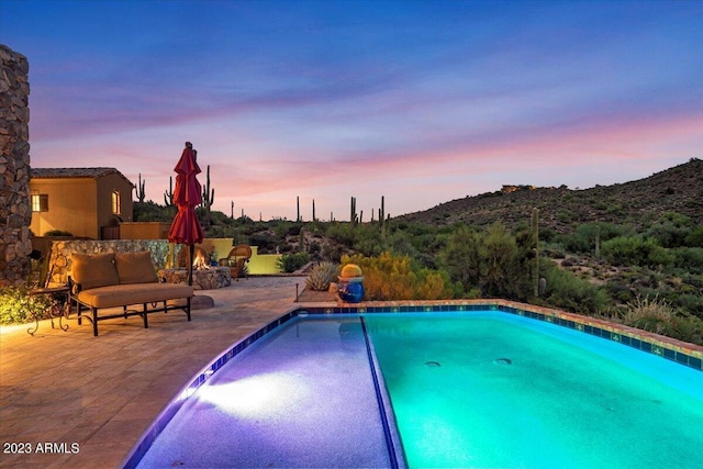 pool at dusk with a patio