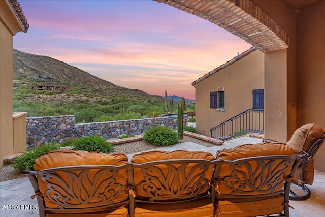 patio terrace at dusk with a mountain view and an outdoor living space