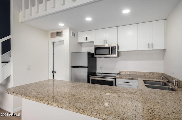 kitchen with sink, kitchen peninsula, white cabinets, and stainless steel appliances