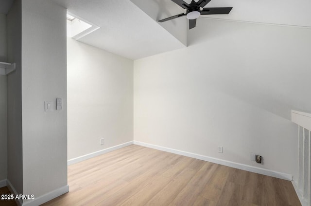 empty room featuring ceiling fan, vaulted ceiling, and light hardwood / wood-style floors