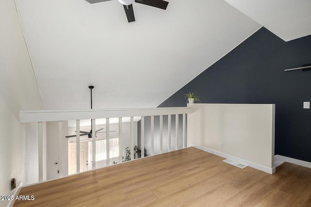 stairs with vaulted ceiling, ceiling fan, and hardwood / wood-style floors