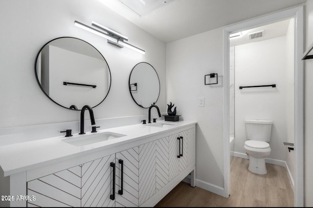 full bathroom with shower / bathing tub combination, hardwood / wood-style floors, toilet, and vanity