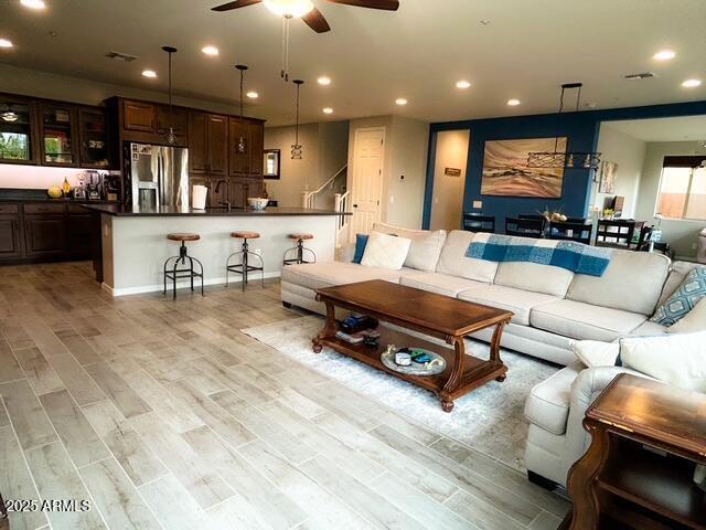 3871 E Harrison St, Gilbert, AZ 85295 - living room featuring light wood-style flooring, visible vents, ceiling fan, recessed lighting, and stairs