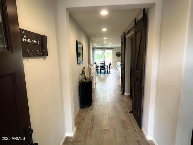 3871 E Harrison St, Gilbert, AZ 85295 - hallway with a barn door, recessed lighting, light wood finished floors, and baseboards