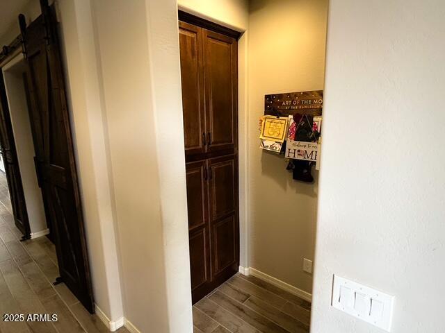 3871 E Harrison St, Gilbert, AZ 85295 - corridor featuring baseboards, a barn door, and dark wood-style flooring