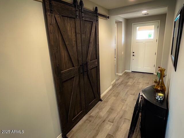 3871 E Harrison St, Gilbert, AZ 85295 - entryway with baseboards, a barn door, and light wood-style floors