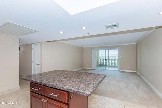 7970 E Camelback Rd Unit 604, Scottsdale, AZ 85251 - kitchen featuring crown molding, baseboards, a kitchen island, recessed lighting, and light carpet