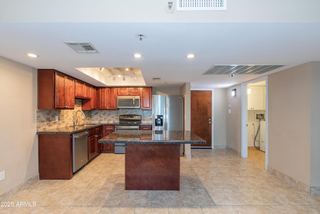 7970 E Camelback Rd Unit 604, Scottsdale, AZ 85251 - kitchen featuring appliances with stainless steel finishes, backsplash, a kitchen island, dark stone countertops, and baseboards