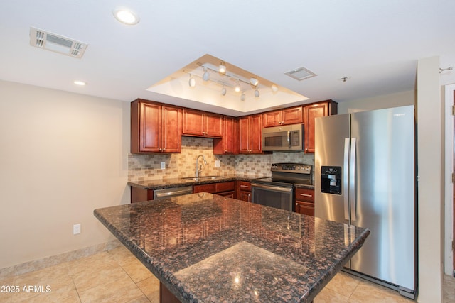 7970 E Camelback Rd Unit 604, Scottsdale, AZ 85251 - kitchen featuring stainless steel appliances, a sink, tasteful backsplash, a raised ceiling, and baseboards