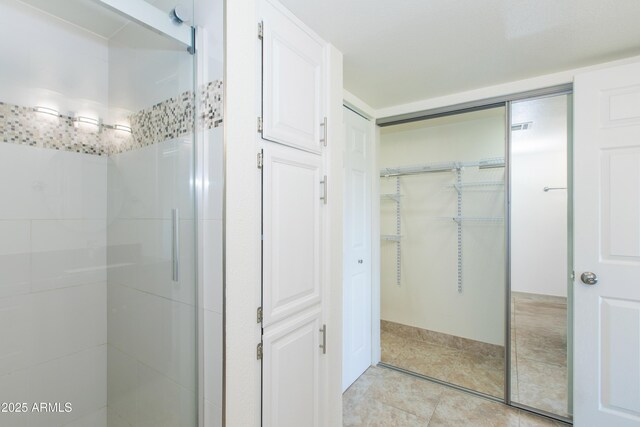 7970 E Camelback Rd Unit 604, Scottsdale, AZ 85251 - full bath featuring a shower stall, a walk in closet, and tile patterned flooring