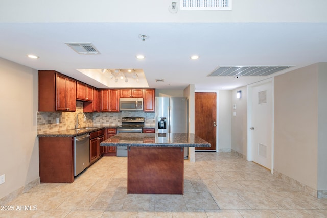7970 E Camelback Rd Unit 604, Scottsdale, AZ 85251 - kitchen with stainless steel appliances, decorative backsplash, a kitchen island, dark stone countertops, and recessed lighting