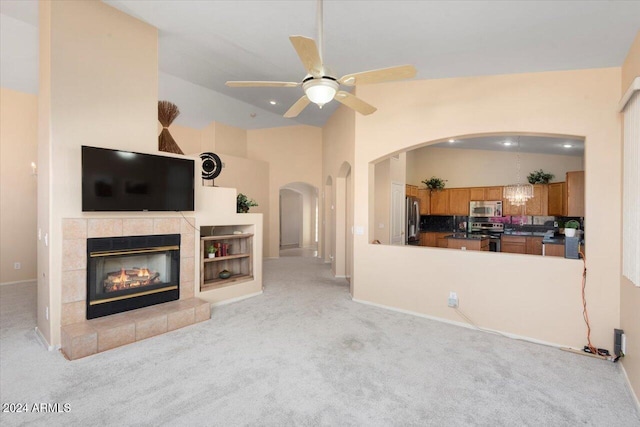 living room with sink, a fireplace, ceiling fan, lofted ceiling, and light colored carpet