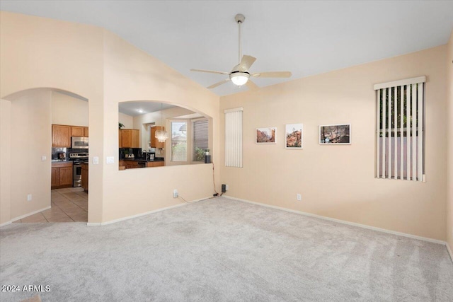 carpeted empty room featuring ceiling fan and vaulted ceiling